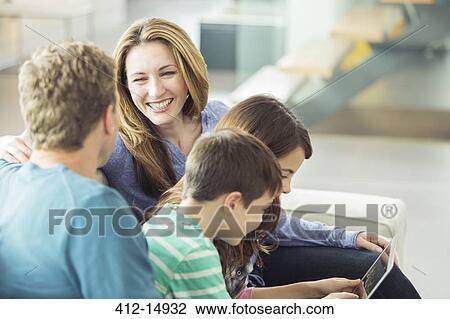 Stock Image - Family relaxing together in living room. Fotosearch