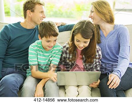 Family relaxing together on sofa View Large Photo Image Stock Photograph - Family relaxing together on sofa. Fotosearch
