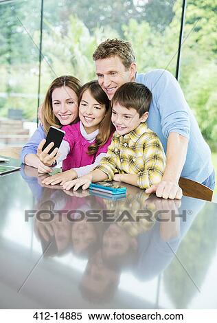 Stock Photography - Family taking cell phone picture together. Fotosearch