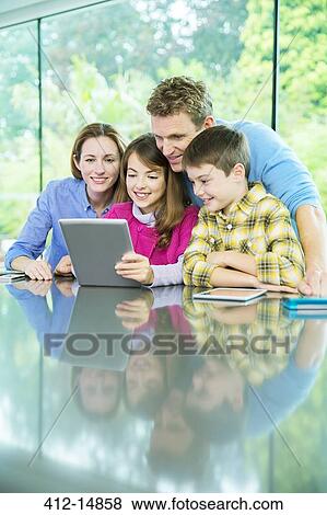 Stock Photo - Family using digital tablet together. Fotosearch