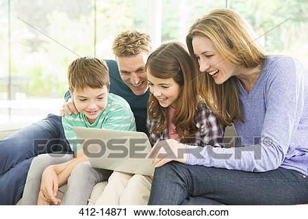 Family using laptop in living room View Large Photo Image Stock Image - Family using laptop in living room. Fotosearch