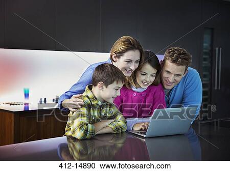 Family using laptop together in kitchen View Large Photo Image Stock Image - Family using laptop together in kitchen. Fotosearch