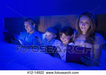 Family using technology in bed View Large Photo Image Stock Image - Family using technology in bed. Fotosearch