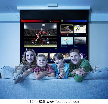 Stock Photograph - Family watching multi screen television in living room. Fotosearch