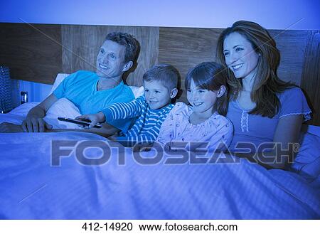 Family watching television in bed View Large Photo Image Stock Image - Family watching television in bed. Fotosearch