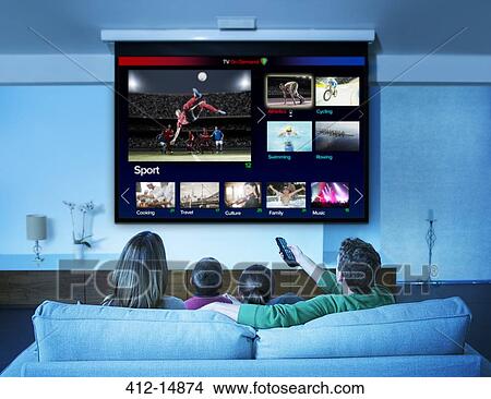 Family watching television in living room View Large Photo Image Picture - Family watching television in living room. Fotosearch