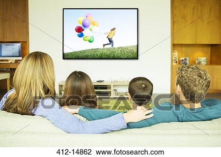 Family watching television in living room View Large Photo Image Stock Image - Family watching television in living room. Fotosearch