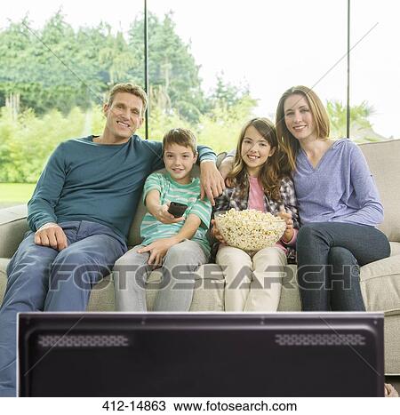 Family watching television in living room View Large Photo Image Stock Image - Family watching television in living room. Fotosearch