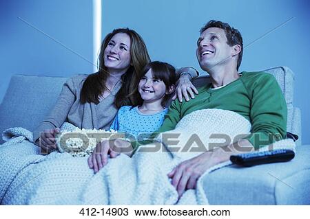 Stock Image - Family watching television in living room. Fotosearch