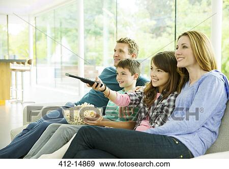 Stock Photo - Family watching television in living room. Fotosearch