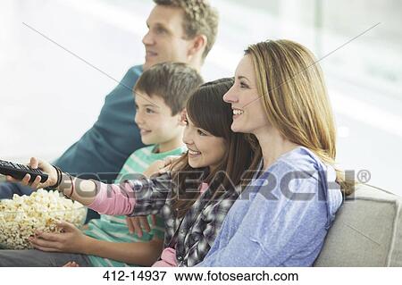 Family watching television in living room View Large Photo Image Stock Photo - Family watching television in living room. Fotosearch
