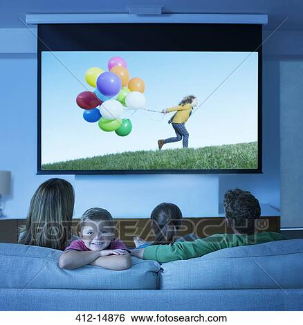 Family watching television in living room View Large Photo Image Stock Photograph - Family watching television in living room. Fotosearch