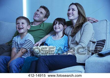 Stock Photography - Family watching television in living room. Fotosearch