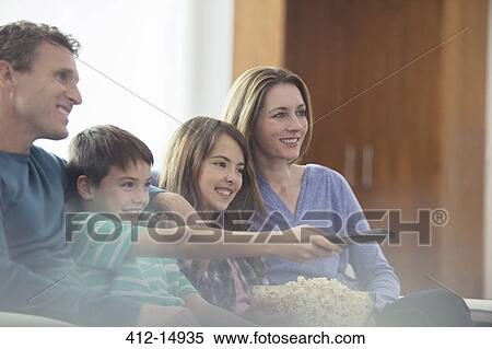 Stock Photography - Family watching television in living room. Fotosearch