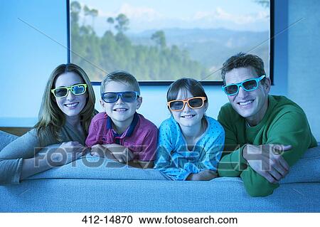 Family wearing 3D glasses in living room View Large Photo Image Stock Image - Family wearing 3D glasses in living room. Fotosearch