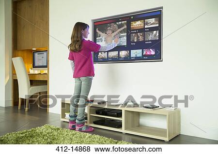 Girl using touch screen television in living room View Large Photo Image Stock Photo - Girl using touch screen television in living room. Fotosearch