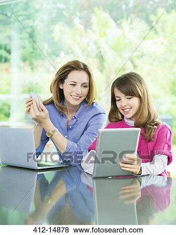 Mother and daughter using technology View Large Photo Image Stock Photo - Mother and daughter using technology. Fotosearch