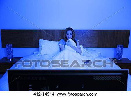 Woman watching television in bed View Large Photo Image Picture - Woman watching television in bed. Fotosearch
