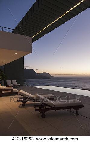 Balcony of modern house overlooking ocean at sunset View Large Photo Image Stock Image - Balcony of modern house overlooking ocean at sunset. Fotosearch