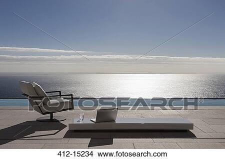 Modern patio and infinity pool overlooking ocean View Large Photo Image Picture - Modern patio and infinity pool overlooking ocean. Fotosearch