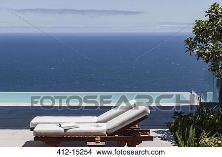 Picture - Modern patio and infinity pool overlooking ocean. Fotosearch