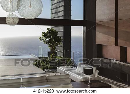 Sofas and tables in modern living room overlooking ocean View Large Photo Image Stock Image - Sofas and tables in modern living room overlooking ocean. Fotosearch