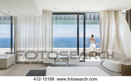 Woman on modern balcony overlooking ocean View Large Photo Image Stock Photograph - Woman on modern balcony overlooking ocean. Fotosearch