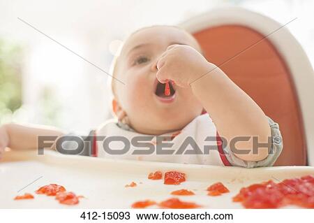 Baby boy eating in high chair View Large Photo Image Stock Image - Baby boy eating in high chair. Fotosearch