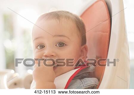 Baby boy eating in high chair View Large Photo Image Stock Image - Baby boy eating in high chair. Fotosearch