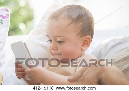 Baby boy playing with cell phone View Large Photo Image Stock Photo - Baby boy playing with cell phone. Fotosearch