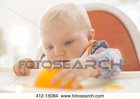 Baby girl playing with gelatin dessert in high chair View Large Photo Image Picture - Baby girl playing with gelatin dessert in high chair. Fotosearch