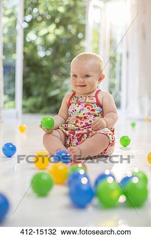 Baby girl playing with toys on floor View Large Photo Image Stock Image - Baby girl playing with toys on floor. Fotosearch