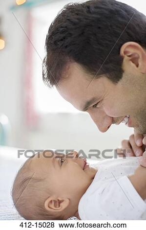 Father adoring baby boy on table View Large Photo Image Stock Photo - Father adoring baby boy on table. Fotosearch