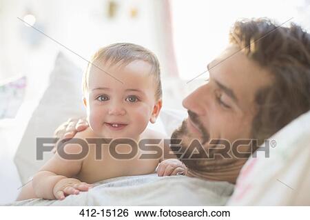 Father and baby boy relaxing on sofa View Large Photo Image Stock Photograph - Father and baby boy relaxing on sofa. Fotosearch
