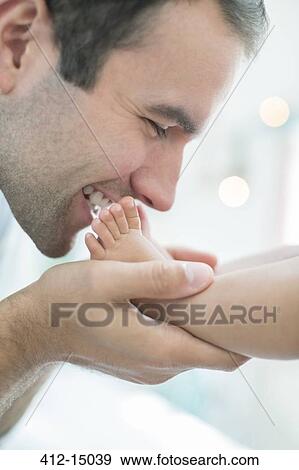 Stock Photo - Father kissing baby boy's feet. Fotosearch