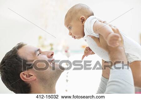 Stock Image - Father playing with baby boy. Fotosearch