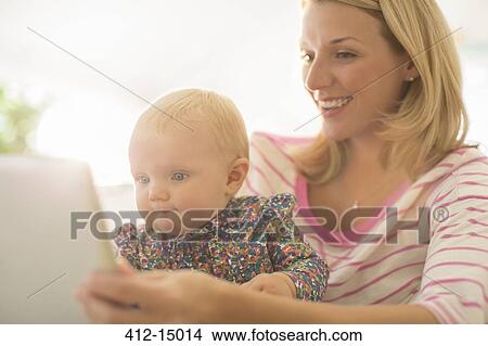 Mother and baby girl using digital tablet View Large Photo Image Picture - Mother and baby girl using digital tablet. Fotosearch