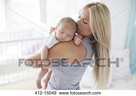 Mother carrying sleeping baby girl View Large Photo Image Stock Photo - Mother carrying sleeping baby girl. Fotosearch