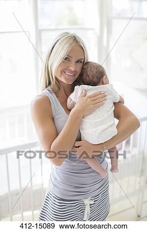 Mother holding baby girl in nursery View Large Photo Image Stock Photo - Mother holding baby girl in nursery. Fotosearch