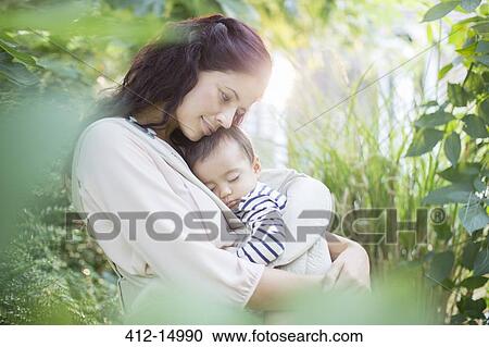 Mother holding baby girl outdoors View Large Photo Image Stock Image - Mother holding baby girl outdoors. Fotosearch