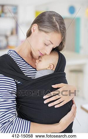 Stock Photo - Mother holding baby in sling. Fotosearch