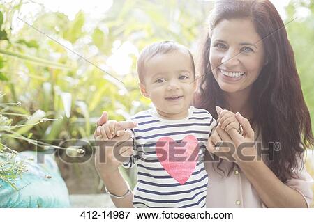 Stock Photo - Mother holding daughter outdoors. Fotosearch