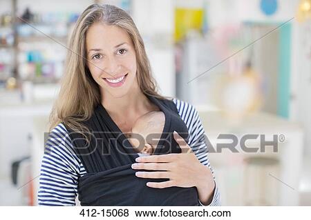 Stock Photo - Mother holding sleeping baby boy in sling. Fotosearch