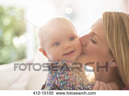 Mother kissing baby girl's cheek View Large Photo Image Stock Photography - Mother kissing baby girl's cheek. Fotosearch