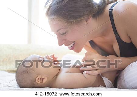 Stock Image - Mother playing with baby boy. Fotosearch