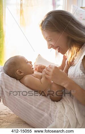 Stock Photography - Mother playing with baby boy. Fotosearch