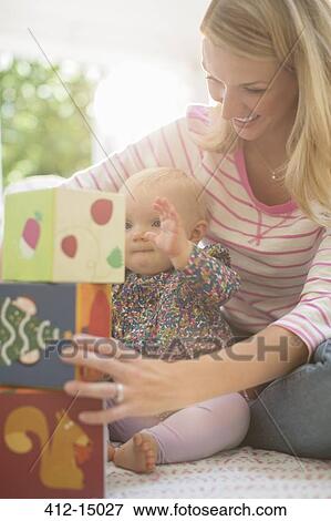 Mother playing with baby girl on floor View Large Photo Image Stock Photo - Mother playing with baby girl on floor. Fotosearch