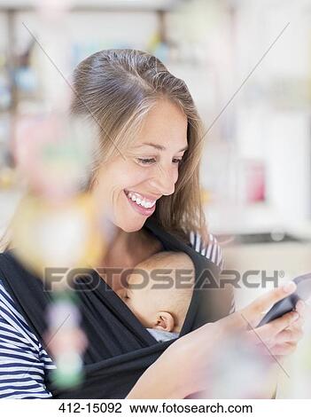 Mother with baby boy using cell phone View Large Photo Image Stock Image - Mother with baby boy using cell phone. Fotosearch
