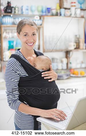 Mother with baby boy using laptop in kitchen View Large Photo Image Stock Image - Mother with baby boy using laptop in kitchen. Fotosearch
