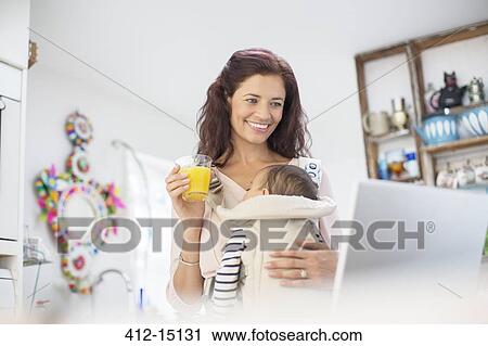 Mother with baby girl using laptop in kitchen View Large Photo Image Stock Image - Mother with baby girl using laptop in kitchen. Fotosearch